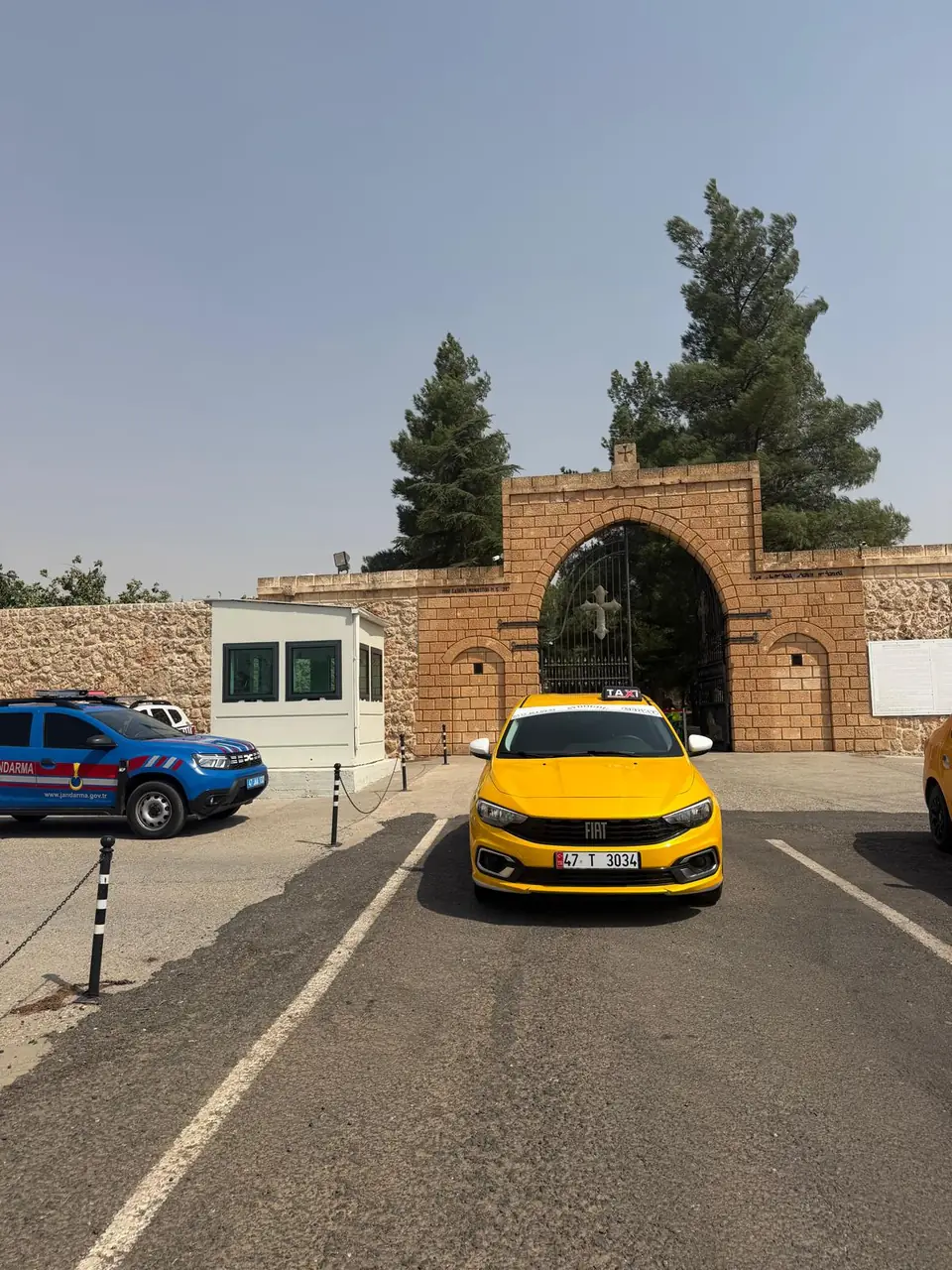 Midyat çevresinde taş duvarlı bir manastır girişinde taksi